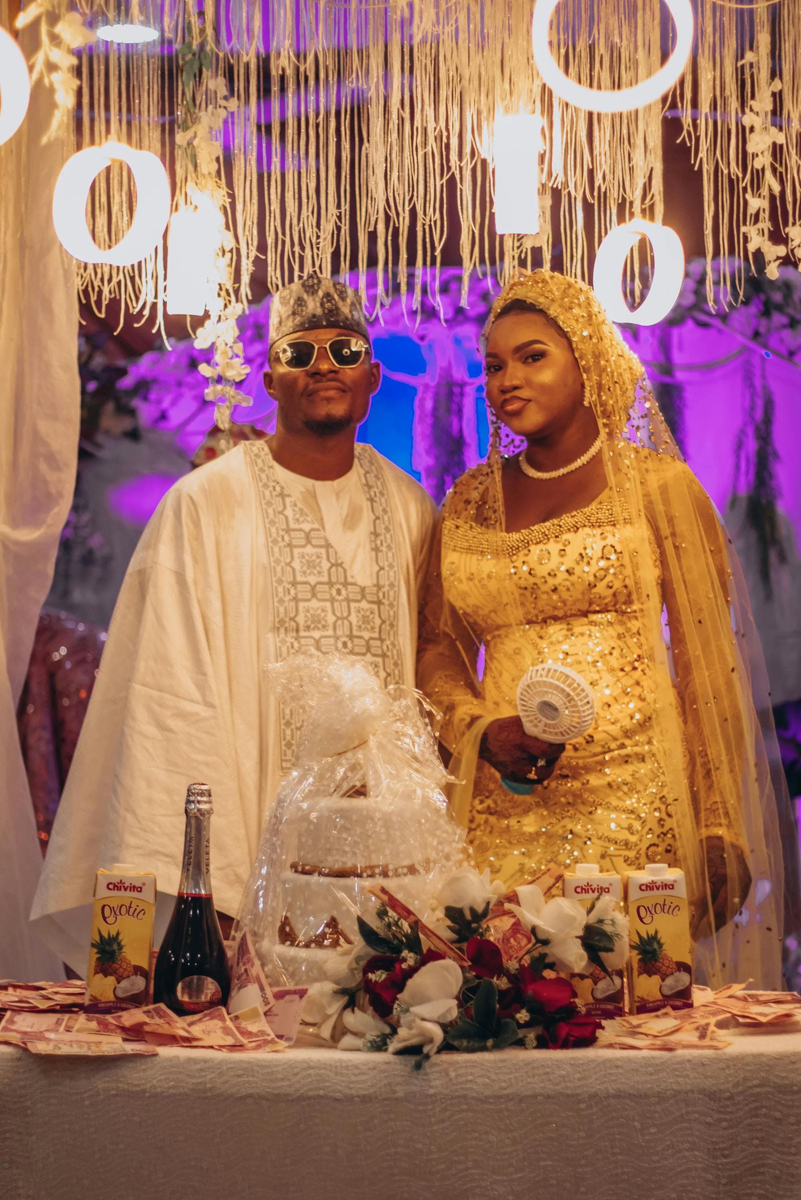 African wedding celebration with decorated event tables and traditional attire.