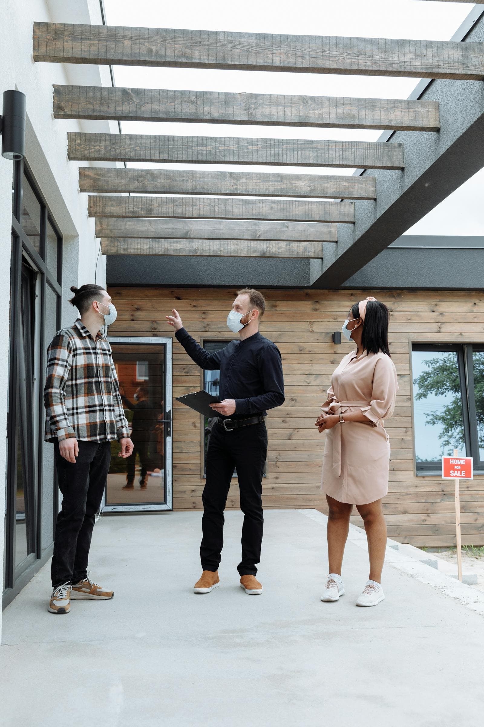 African real estate agent showing clients a modern house.